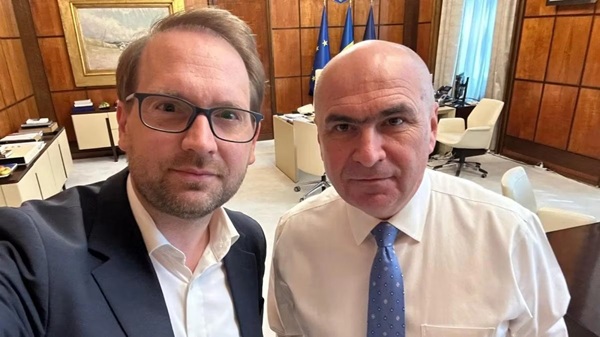 ilie bolojan in camasa alba cu cravata albastra alaturi de dominic fritz in costum albastru