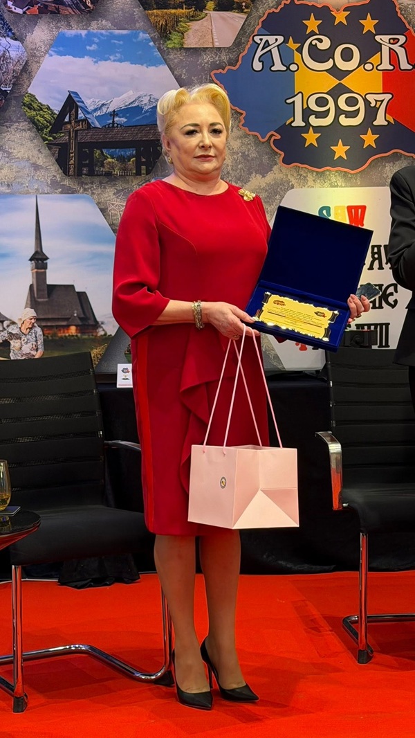 viorica dancila imbracata in rochie midi rosie tine un premiu n mana