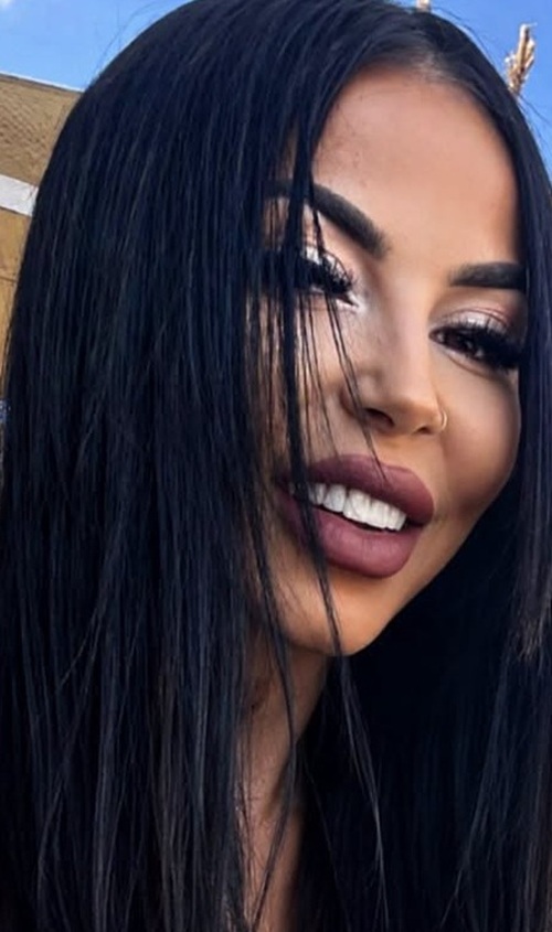 denisa paun femeie bruneta cu parul lung zambeste la camera