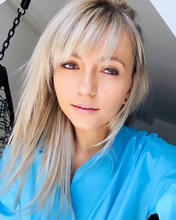 femeie blonda cu parul lung drept cu camasa bleu