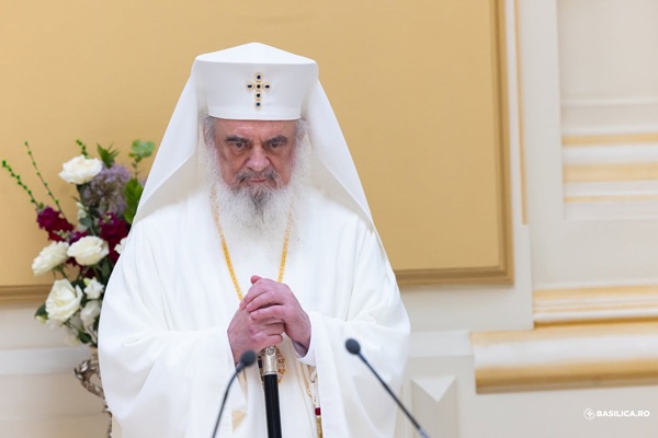 patriarhul daniel imbracat in alb cu mainile impreunate vorbeste la microfon