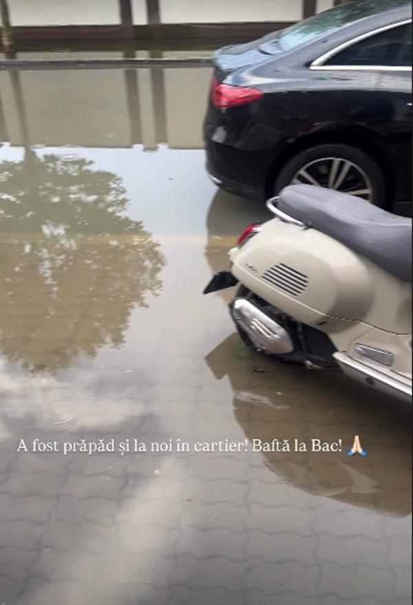 curte inundata cu apa in fundal o masina si un scuter