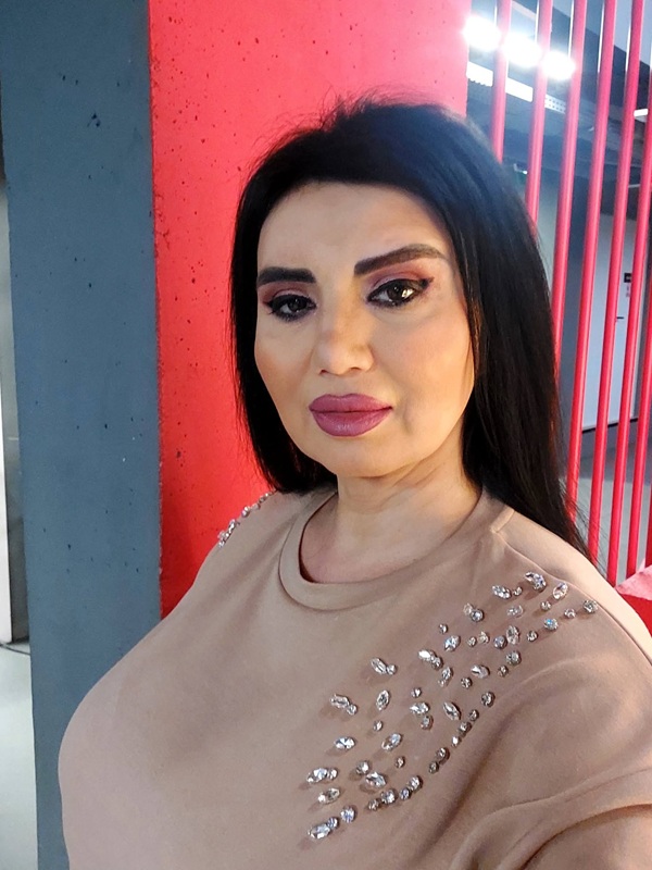 adriana balmuteanu cu parul desprins imbracata in bluza crem face un selfie