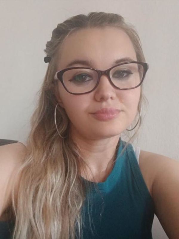 femeie blonda cu parul lung prins intr-o parte in maieu verde