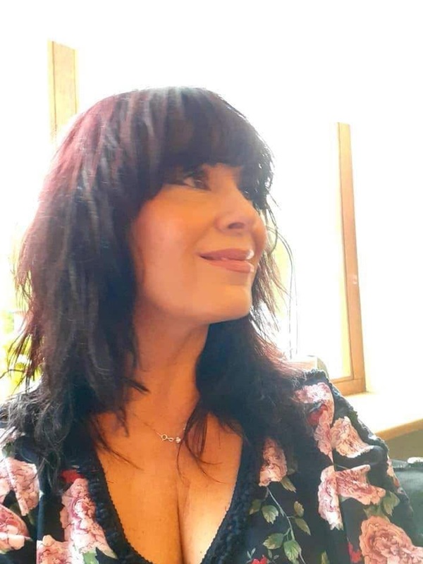 mariana moculescu cu parul lung desprins in bluza cu flori zambeste