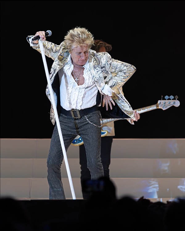 rod stewart in pantaloni negri si sacou argintiu canta pe scena