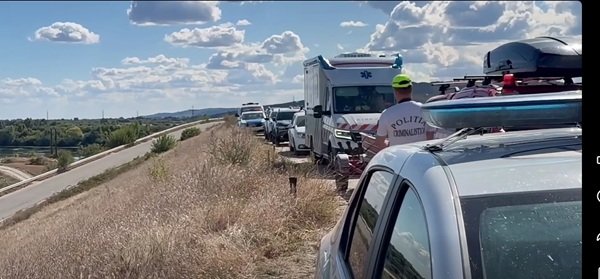 mai multe masini de politie pe un dig langa un rau