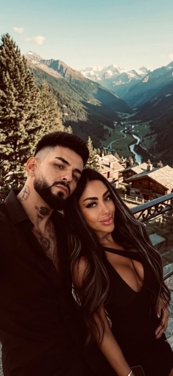 femeie bruneta in rochie neagra alaturi de barbat in costum negru