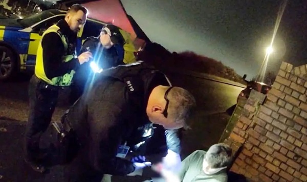 politisti adunati la locul crimei cauta ceva la lumina lanternei