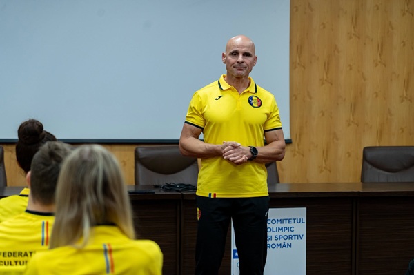 daniel oprea imbracat in galben tine un curs intr-o sala de clasa