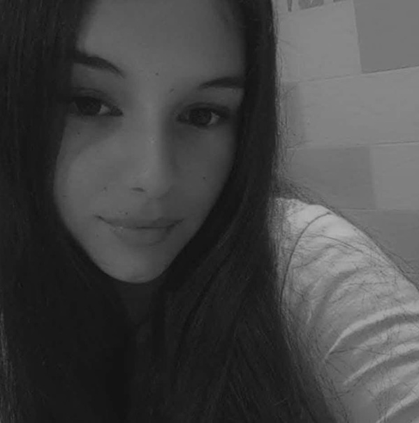 fata cu parul lung in bluza cu maneci lungi face un selfie