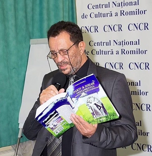 vasile ionescu tine o carte in mana si citeste la microfon din ea