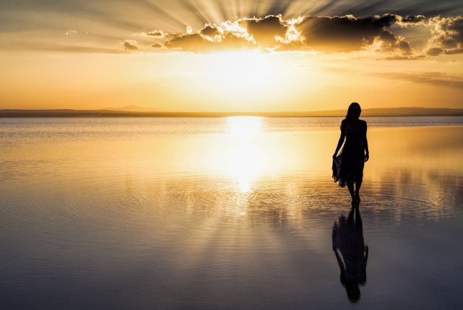 femeie pe plaja la apus de soare
