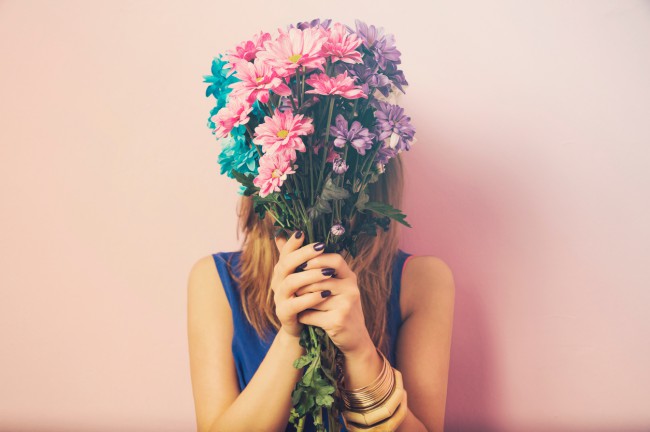 femeie care isi ascunde fata cu flori