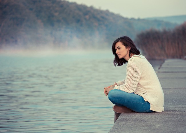femeie trista pe marginea lacului