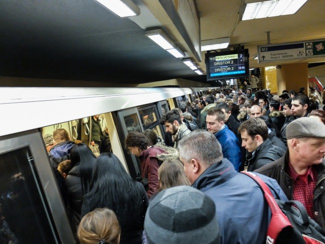 oameni care urca in metrou