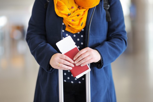 femeie cu bilet de avion si pasaport in mana