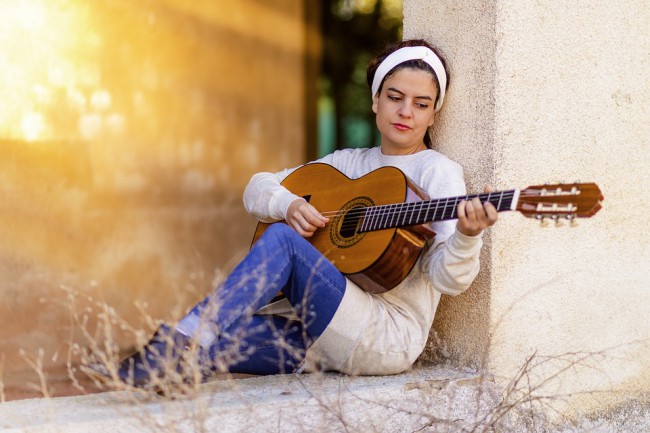 femeie care canta la chitara