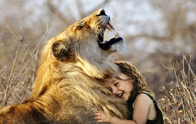fetita care imbratiseaza un leu