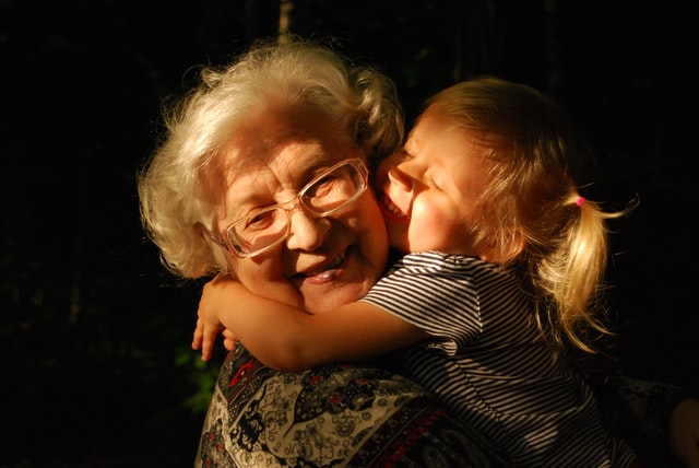 O bunică care își îmbrățișează călduros nepoțica