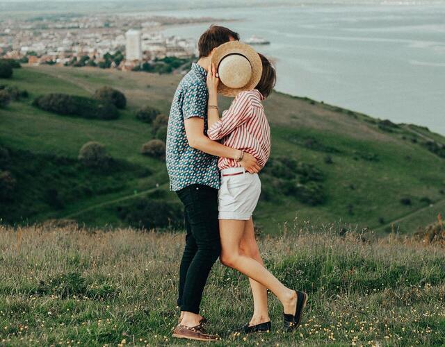 Cuplu de îndrăgostiți care se sărută după o pălărie