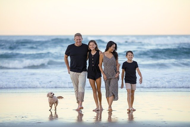 Familie de 4 membri fericiți pe plajă