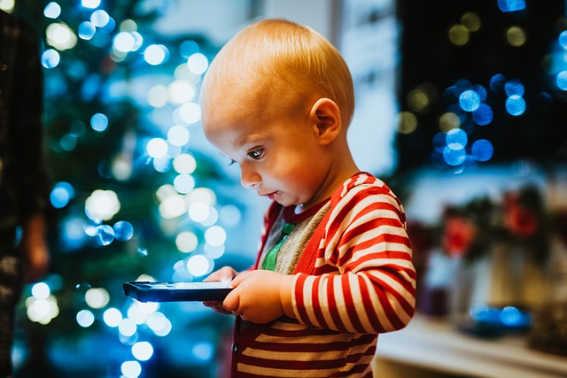 Copil care privește ecranul unui smartphone
