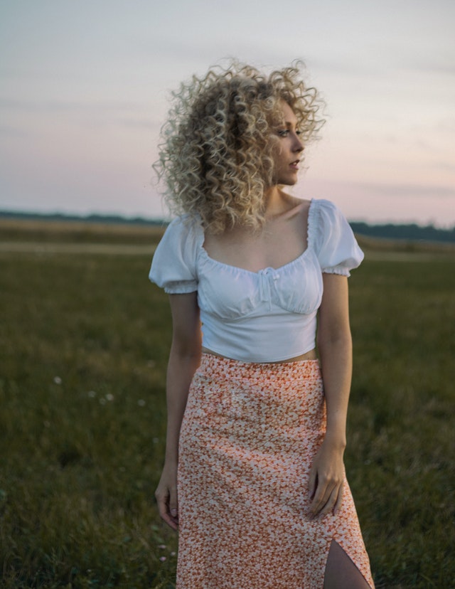 Femeie blondă în fustă pe câmp