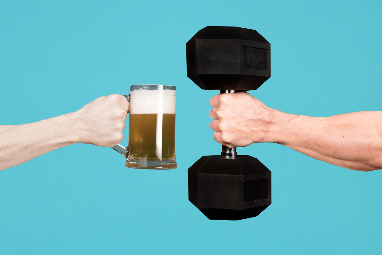 Persoane care țin în mâini o halbă de bere și o greutate fitness