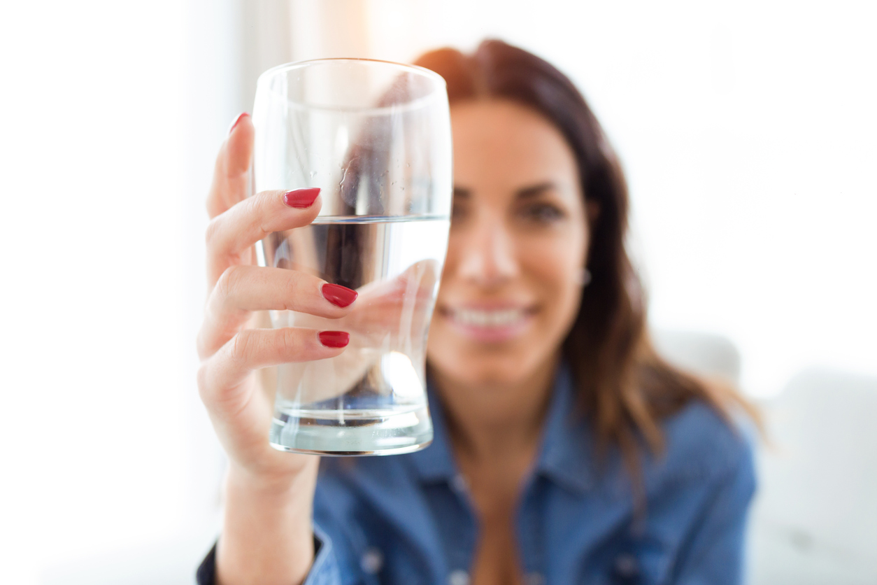 Femeie cu un pahar de apă în mână