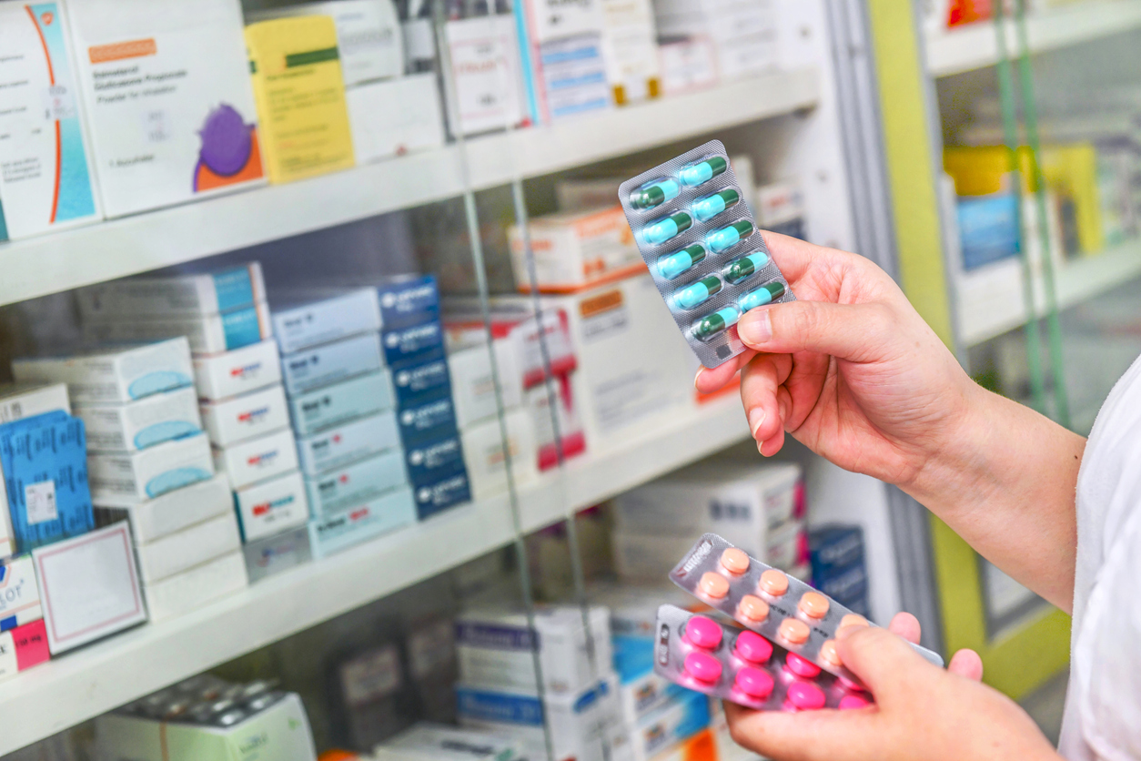 Femeie care cu medicamente în mână în farmacieft