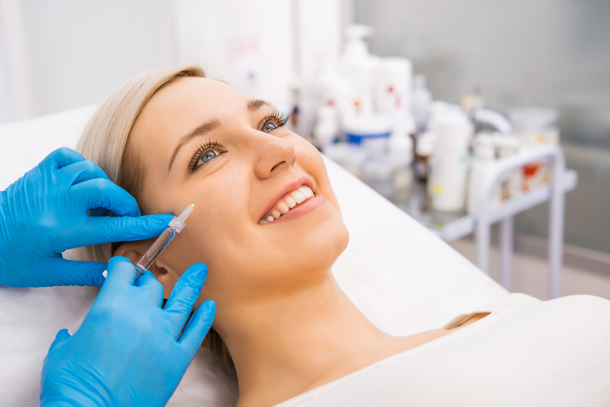 Femeie care își injectează fillere cosmetice pe față