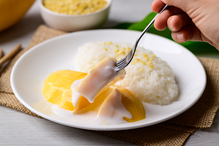 Farfurie albă cu orez lipicios și sos de mango