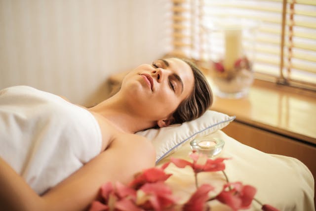 Femeie care stă întinsă pe pat relaxată