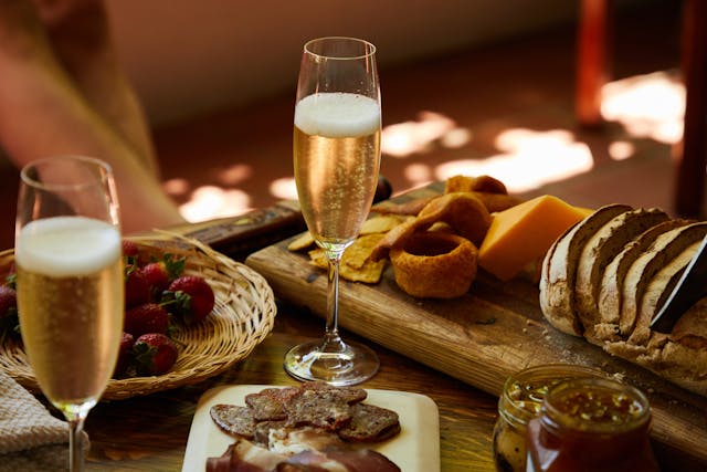 Pahar de vin spumant pe masă cu diverse aperitie