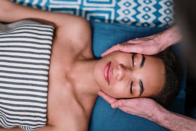 Femeie care isi face masaj facial la salon