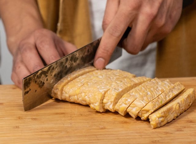 Persoana care taie tempeh felii