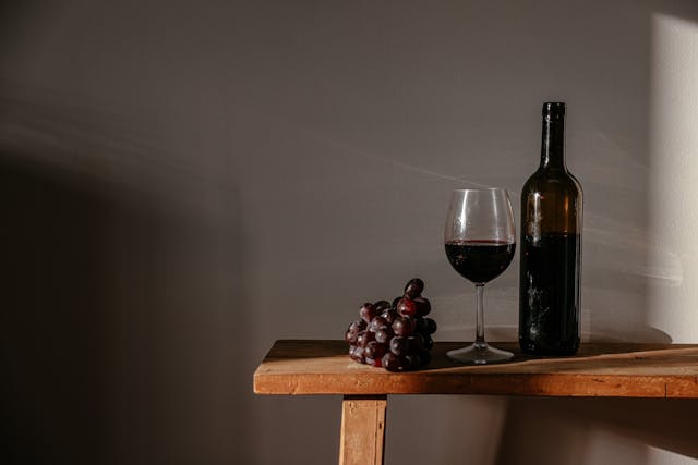 Pahar de vin roșu și struguri
