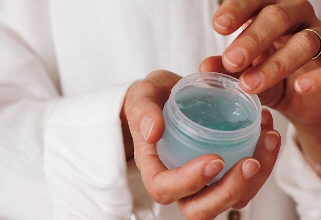 Femeie cu un recipient de crema in mana