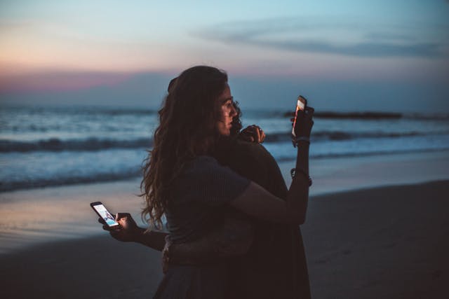 Cuplu imbratisat care se uita pe telefon