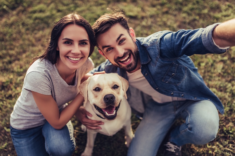 Cuplu fericit care petrece timp în natură cu animalul de companie