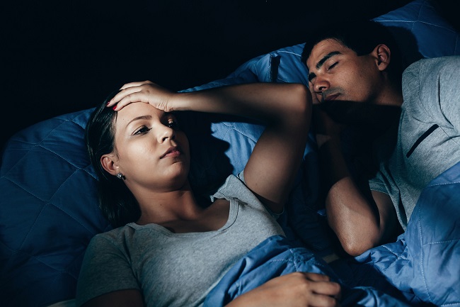 Femeie care nu se poate odihni noaptea pentru că este deranjată de sforăitul soțului său