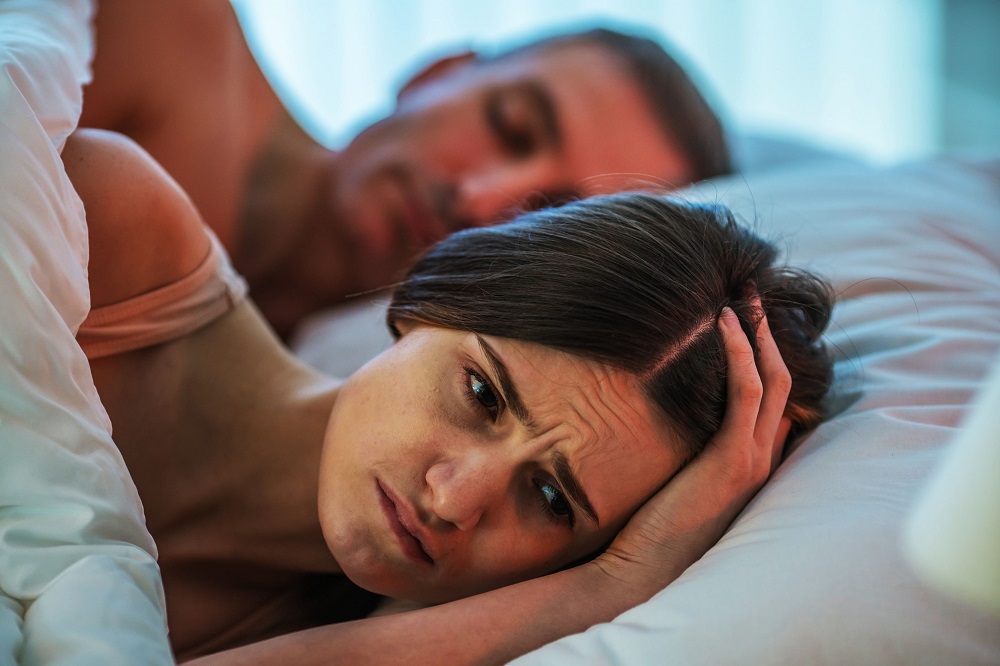 Femeie supărată, după o ceartă cu soțul său care a adormit înainte să rezolve problemele. El doarme liniștit, în timp ce ea se luptă cu gândurile negative.