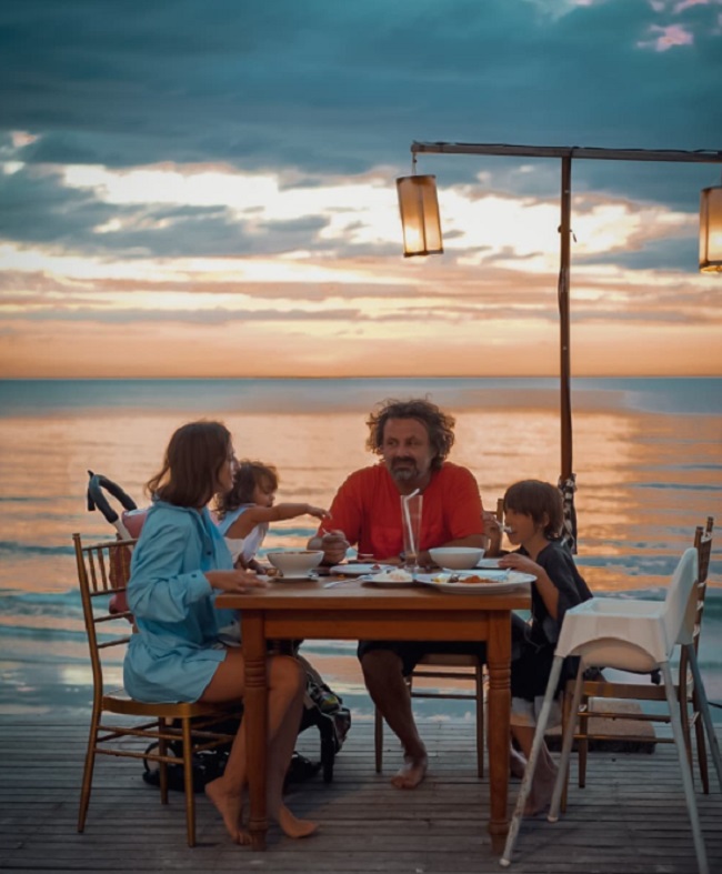 Dana Rogoz și Radu Dragomir, luând cina pe o plajă din Thailanda, alături de copiii lor, Vlad și Lia.