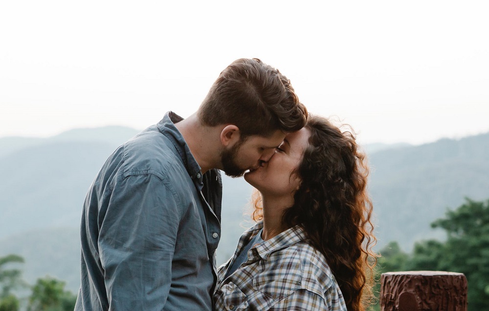 Cuplu care se sărută pasional într-o zonă de munte