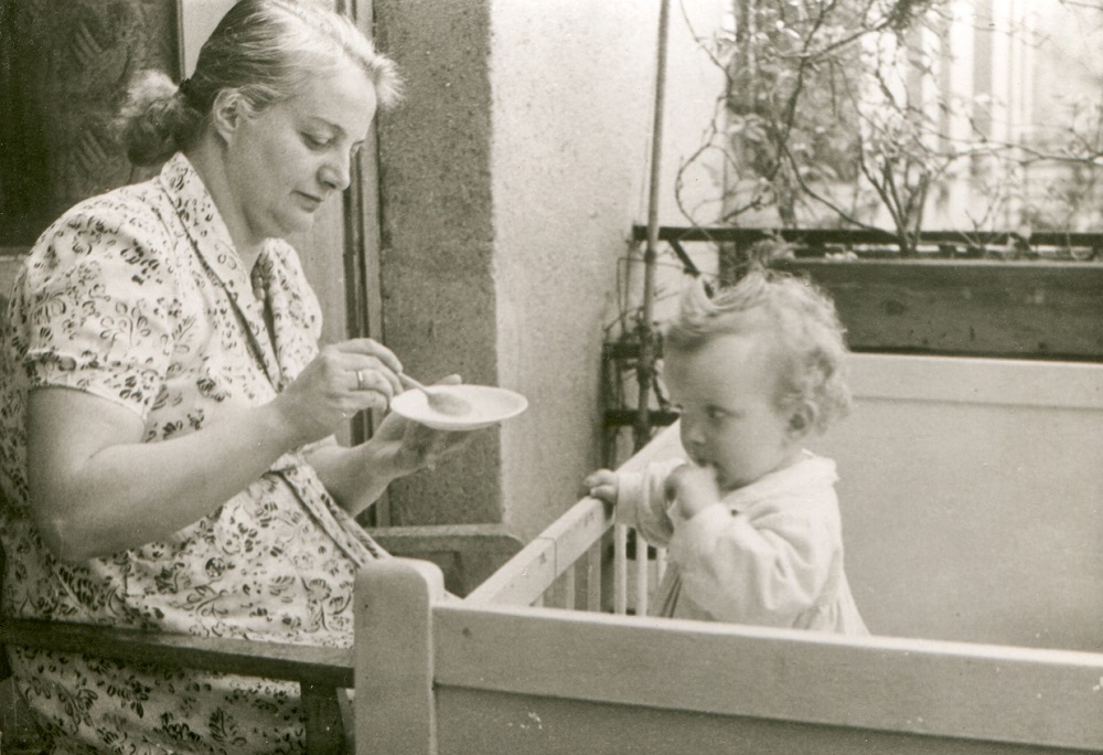 Mamă adoptivă care își hrănește cu lingurița copilul foarte mic