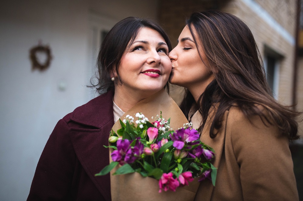 Femeie care i-a oferit mamei sale un buchet de flori în nuanțe de mov și roz