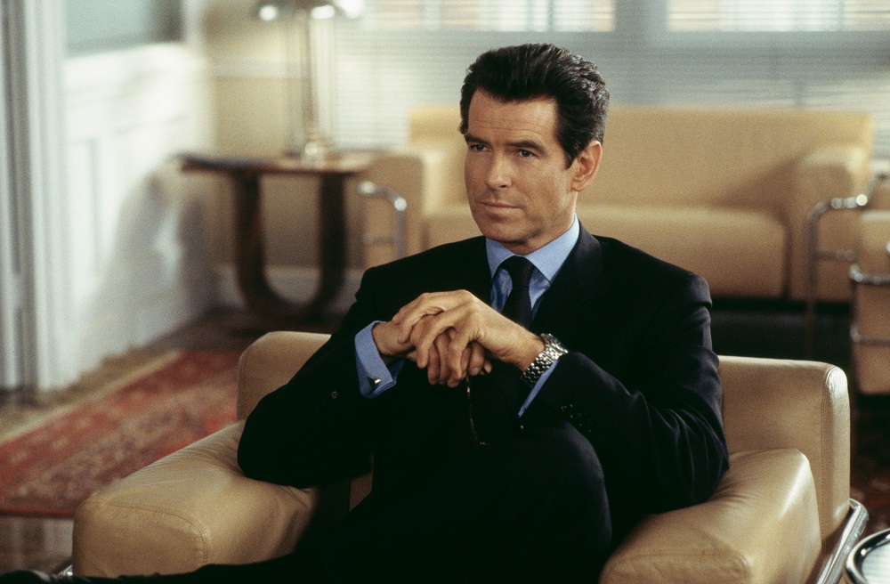Pierce Brosnan în rolul lui James Bond, stând pe canapea în biroul domnului Swiss