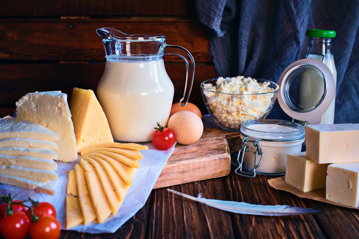 Masă plină cu produse lactate: brânză, lapte, unt, smântână, cașcaval.