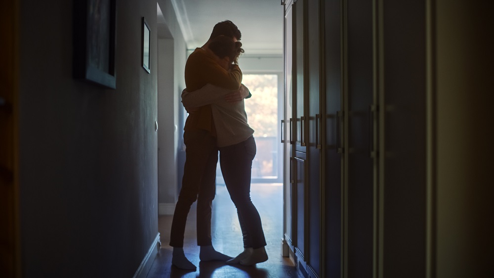 Cuplu trist, îmbrățișat în holul casei